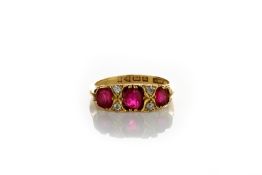 An 18ct gold Victorian three stone ruby ring, with diamond points, in claw setting