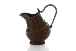 An unusual Persian bronze jug, finely engraved all over with flowers and scrolling leaves, the