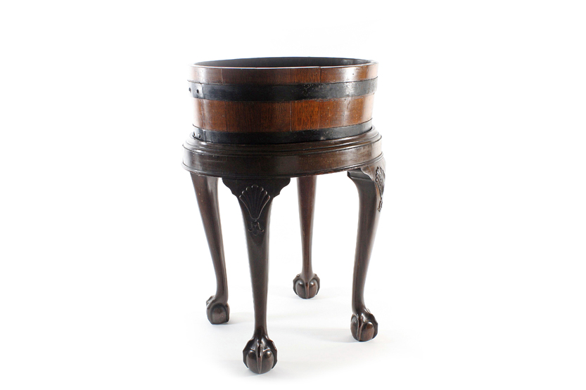 A George III mahogany oval planter on stand, of segmented brass bound construction with tin liner