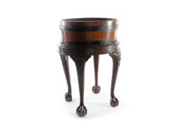 A George III mahogany oval planter on stand, of segmented brass bound construction with tin liner