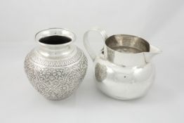 An Indian white metal vase the ovoid body vase chased with leaves and flowers engraved around the