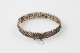 A Continental gold coloured metal stiff bangle 19th century, set with numerous seed pearls and