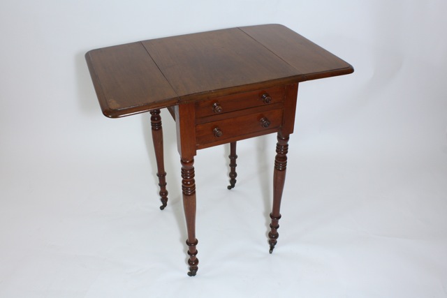 An early Victorian mahogany pembroke table with drop leaves, two drawers raised on ring turned