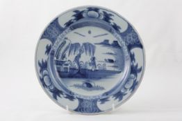 An 18th century English delft plate the border with vignettes of flowers the central panel with