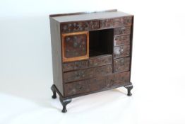 A Chinese cabinet early 20th century, fitted with a central cupboard and an arrangement of nine