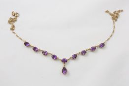 An Edwardian 9ct gold and amethyst necklace circa 1900, the chain link necklace set with ten faceted