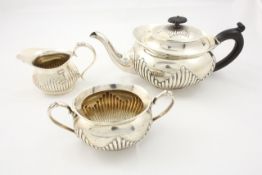 A three piece silver tea set hallmarked Sheffield, 1919, comprising a teapot with ebonised handle