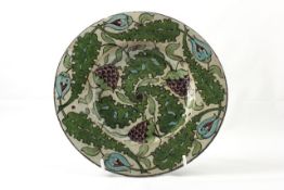 A William de Morgan pottery plate circa 1872, painted in greens, blues and browns on a cream ground,