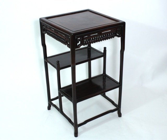 A Chinese rosewood tiered table early 20th century, the square top above a pierced frieze, and two
