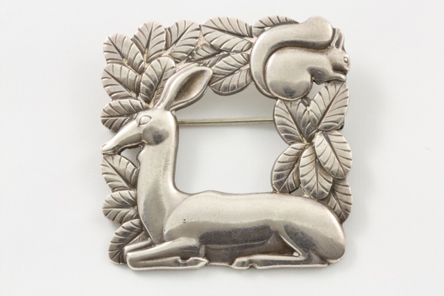 A Georg Jensen deer and squirrel brooch import marks for 1964, pattern number 318 of square form