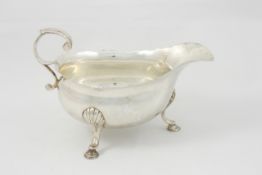 A George III sauce boat hallmarked London 1748/9, with scroll handle, shaped rim, raised on three