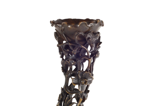 A full-tip rhinoceros horn carving on stand Qing Dynasty 19th century, the tapering horn a mixture