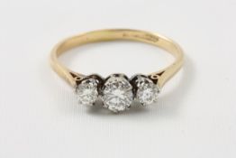 An 18ct gold three stone diamond ring probably 1930s, with coronet settings Good overall