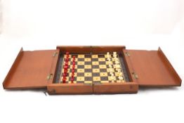 A travelling chess set English, early 20th century, the rectangular mahogany case opening up to