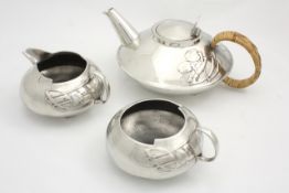 A three piece pewter tea set designed by Archibald Knox circa 1905, the teapot with hinged lid and