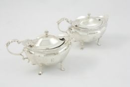 A pair of silver salts hallmarked London 1905/06, of shaped form raised on four high feet, with blue
