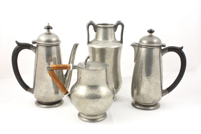 A pewter Liberty & Co coffee pot circa 1905, of hammered design with wooden handle and finial