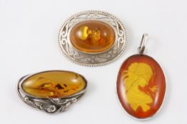 A silver coloured metal framed oval pendant Modern, set with amber intaglio of a young girl with