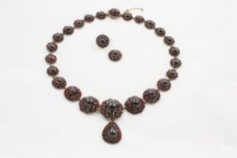 A Victorian garnet necklace each graduated flower head set with cut carbuncle garnet, with similar