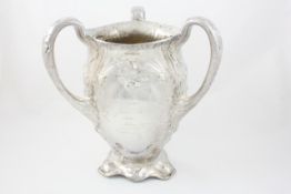 An American silvered metal three handled vase late 19th century, the body of organic form embossed