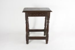 An oak joint stool 17th century, with simple carved frieze, height 56cm In worn condition. Around