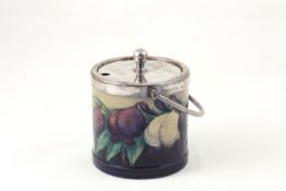 A Moorcroft `Wisteria` preserve pot circa 1925, on blue ground with metal mount, impressed on the