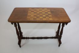 A late Victorian mahogany and satinwood inlaid games table raise on turned end supports and united