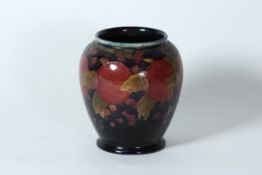 A Moorcroft pottery `Pomegranate` vase circa 1920, on blue ground, with green signature and