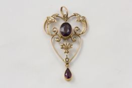 A 9ct gold Edwardian shaped pendant English, circa 1910, set with two almandine garnets and seed