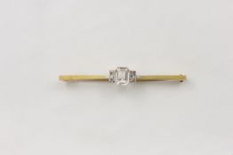 A 9ct gold Art Deco bar brooch 1920s, the centre with clear glass stone and four rose diamonds to