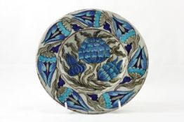 A William de Morgan pottery plate circa 1872, painted in tonal blues and greens depicting stylised
