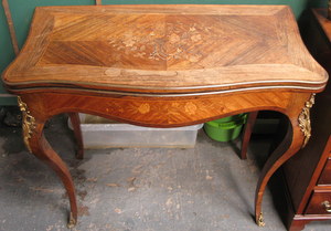 MARQUETRY AND STRING INLAID, ROSEWOOD FOLD OVER GAMES TABLE WITH ORMOLU MOUNTS