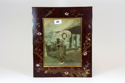 A 1920`s Japanese lacquered photograph frame with hand tinted photograph of young woman with a baby