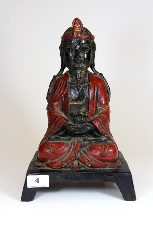 A cold painted early 20thC cast iron figure of Genghis Khan seated in lotus position. With remnants