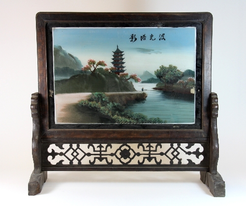 A 19th/20thC Chinese carved wooden table screen with landscape reverse painting on glass W.57cm