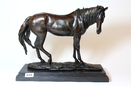 A large bronze figure of a standing horse on a black marble base H.34cm L.41cm