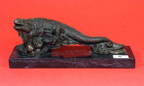 A contemporary bronze figure of an iguana on a black marble base L.32cm