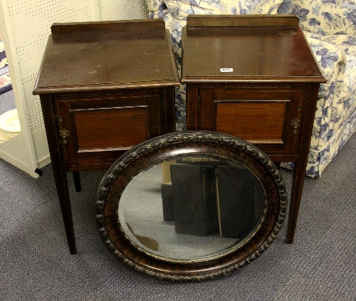 A pair of Edwardian inlaid mahogany bedside cabinets and an oval mirror