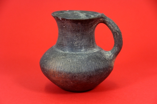 An Neolithic style grey pottery jug with single handle H.12cm understood to be of the period.