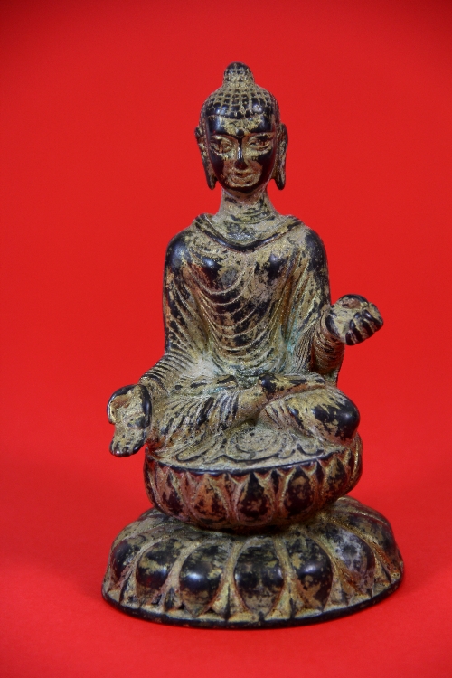 A Chinese bronze figure of a seated Buddha, remnants of gilding H.14cm