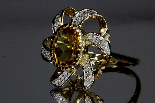 An unusual 9ct yellow gold citrine and diamond cluster ring.Size O