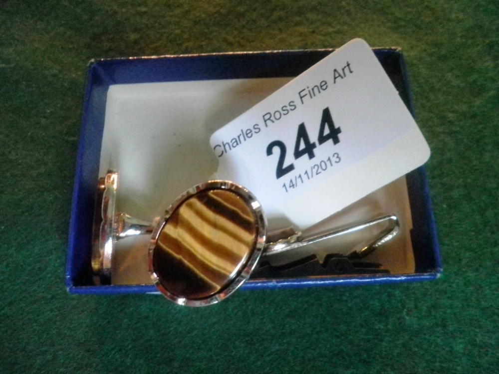 A pair of white metal mounted tigers eye cufflinks, together with a conforming tie clip.