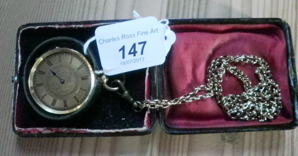 An 18 carat gold cased open face key wind pocket watch, suspended from a long yellow metal chain.