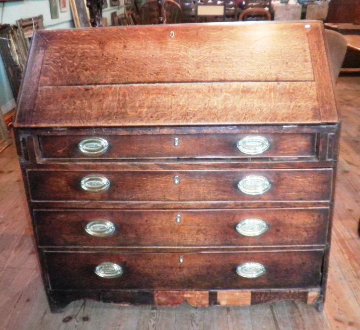 A late 18th/early 19th century oak bureau, the moulded edged fall enclosing fitted interior over