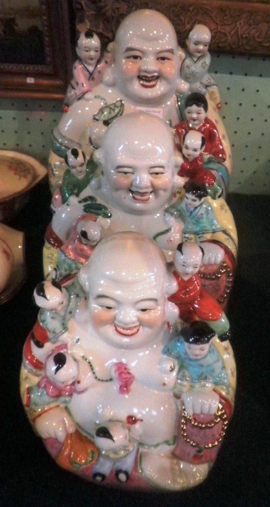 Three modern Oriental ceramic models, each fashioned as a seated grinning Buddha of graduated size.