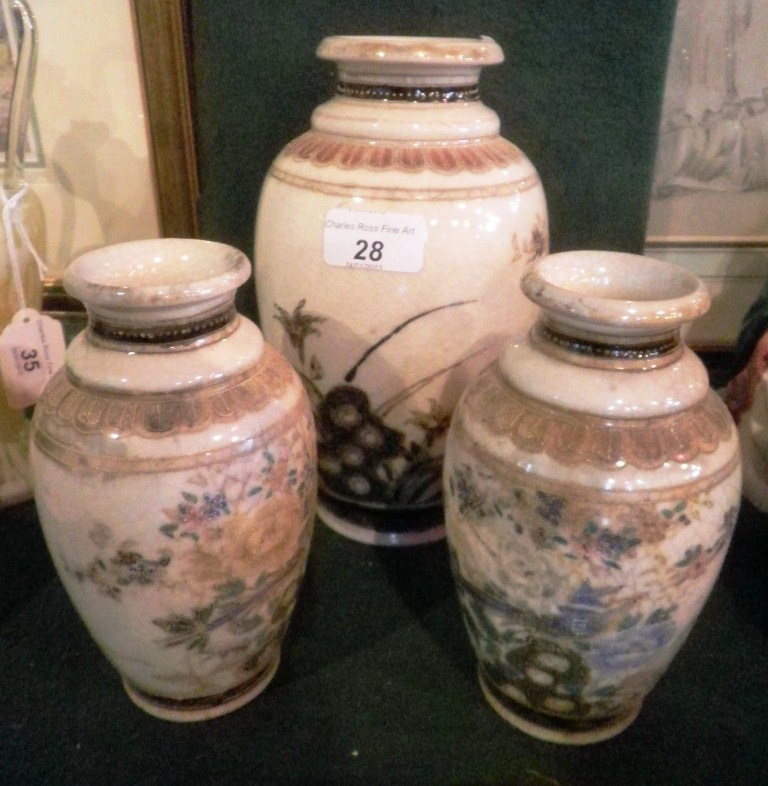 A garniture of three early 20th century Japanese porcelain vases, each decorated with a perched