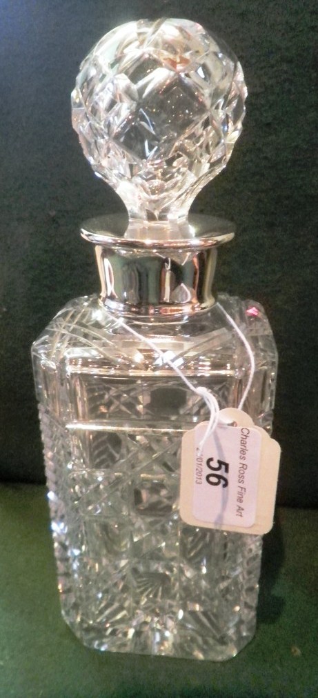 A cut glass decanter of mallet form with silver collar.