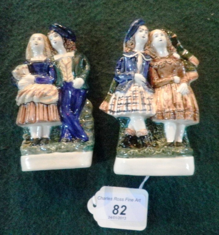 A pair of Staffordshire chimney ornaments, each fashioned as a courting couple on plain oval foot.