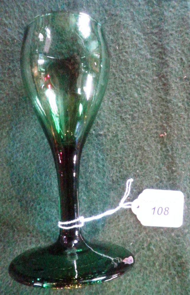 A late 18th century green tinted wine glass, having ovoid bowl, plain stem and conical foot.  16,