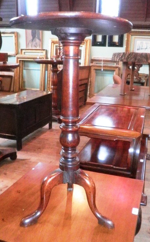 A Victorian mahogany wine table, the circular dished top on gun barrel column, three swept legs